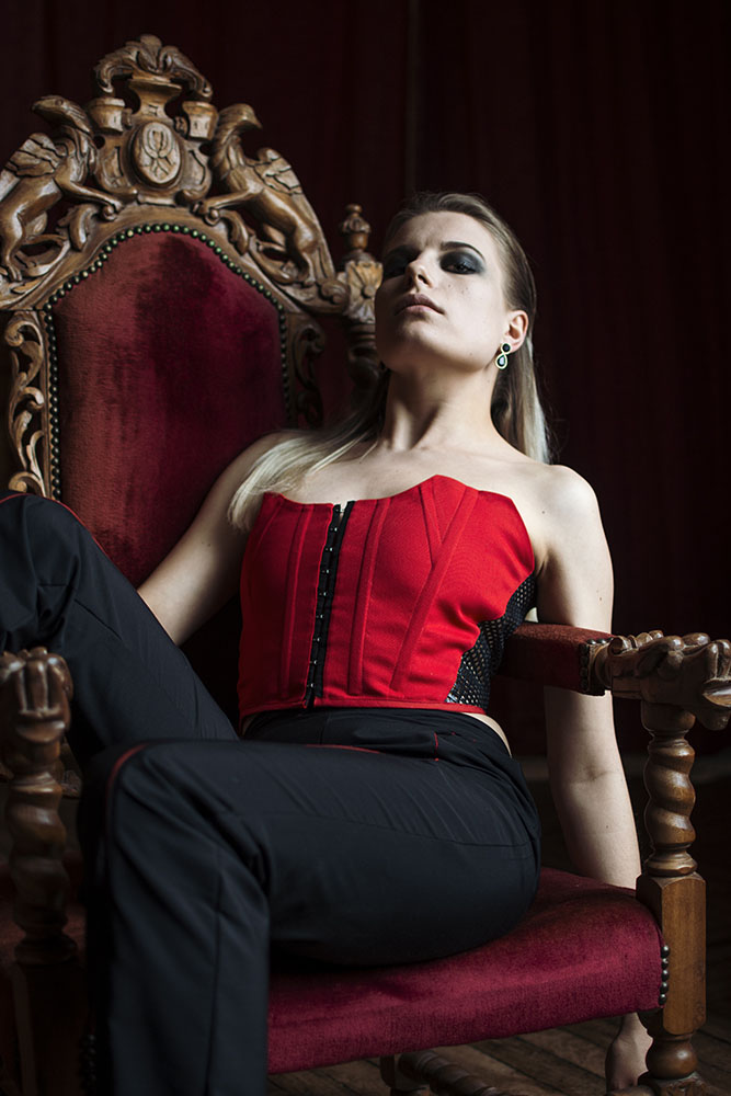 photo de mode. femme assise dans un siège. corset rouge et noir